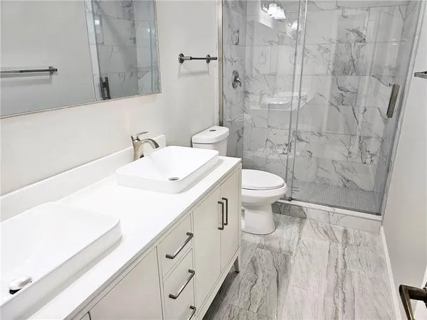 a bathroom with a sink a toilet and a mirror