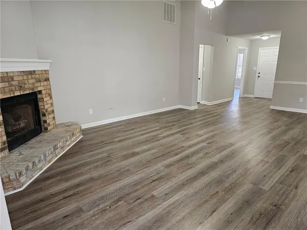 a view of a livingroom with wooden floor and a fireplace