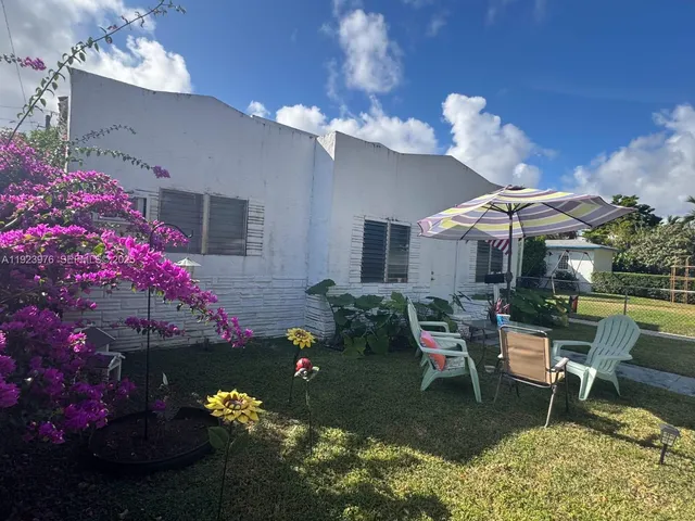 a patio with a table and chairs and a potted plant