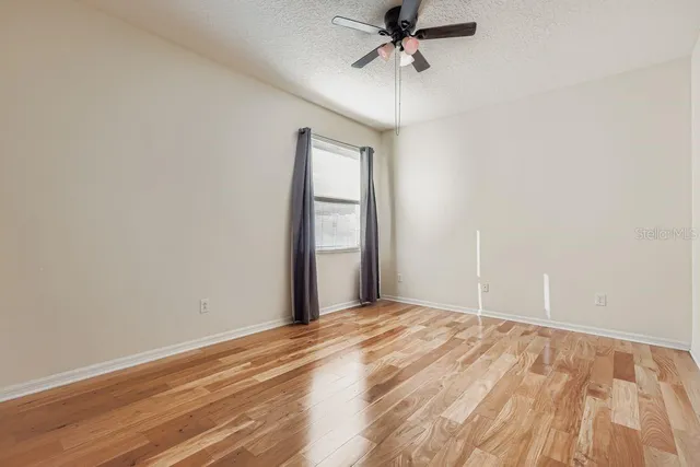 a view of a big room with wooden floor and windows in a room