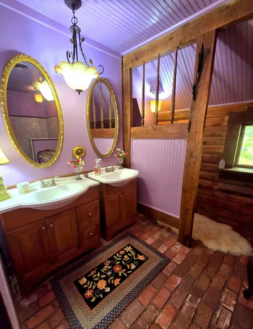 a bathroom with a sink a mirror and painting on the wall