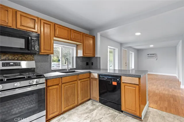a kitchen with stainless steel appliances granite countertop wooden cabinets a sink and a stove