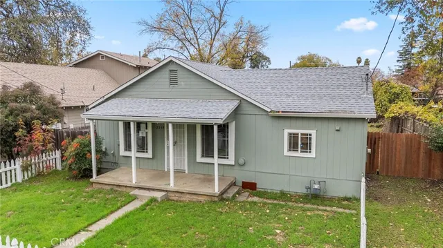 a view of a house with backyard and a tree