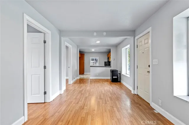 a view of a big room with wooden floor and a window