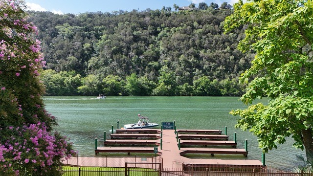 3704 Caney Creek Road Austin, TX 78732 - Photo 39 of 40 A tranquil lake scene with private boat docks nestled against a verdant hillside.