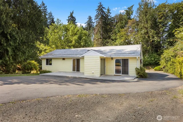 a front view of a house with a yard and trees