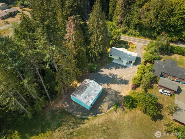 an aerial view of a house with yard and mountain view in back