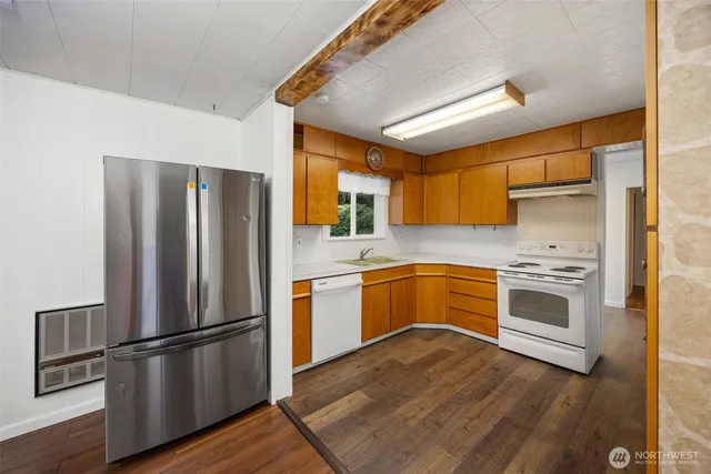 a kitchen with stainless steel appliances wooden floor sink and wooden cabinets