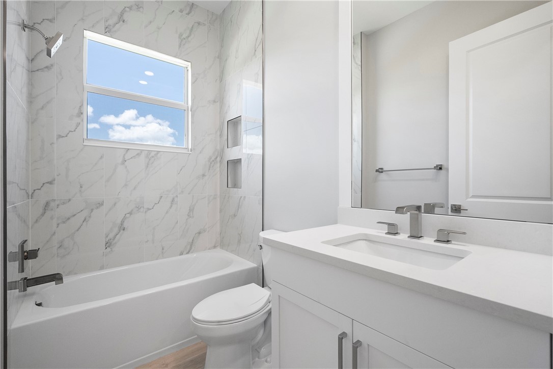 129 Strand Drive Vero Beach, FL 32963 - Photo 16 of 30 a bathroom with a sink a toilet a mirror a bathtub and shower