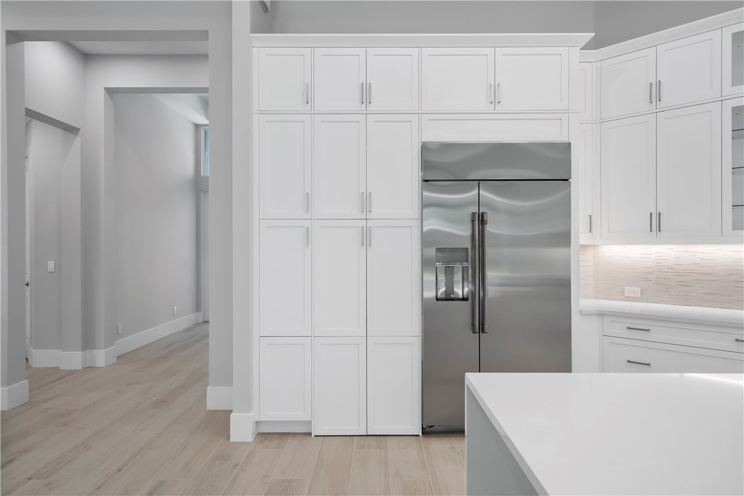 129 Strand Drive Vero Beach, FL 32963 - Photo 8 of 30 a kitchen with white cabinets and refrigerator