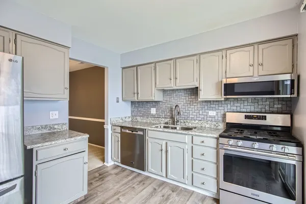 a kitchen with cabinets stainless steel appliances and sink