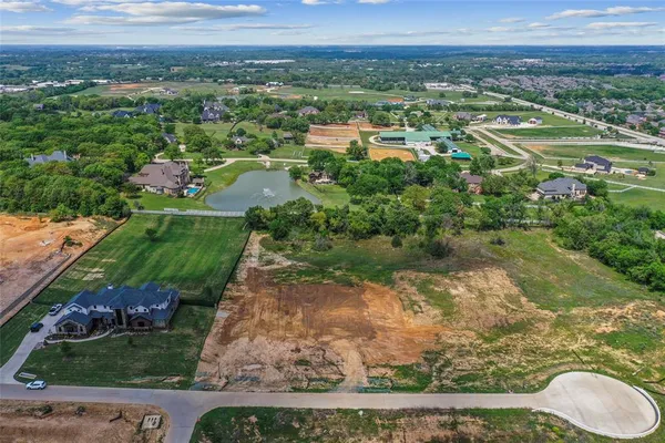 an aerial view of residential houses with outdoor space and trees