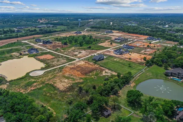 an aerial view of residential houses with outdoor space and trees