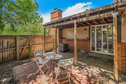 a view of a chair and table in backyard of the house