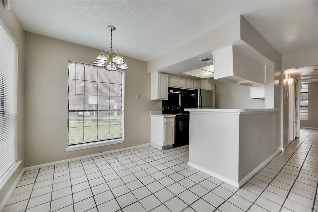 4544 Chaha Road, Unit 106 Garland, TX 75043 - Photo 8 of 17 Kitchen with pendant lighting, white cabinets, light tile flooring, black range with electric cooktop, and a notable chandelier