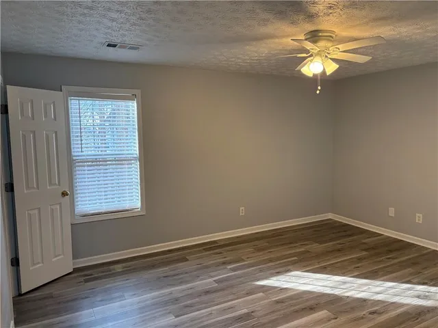a view of a room with wooden floor and a ceiling fan