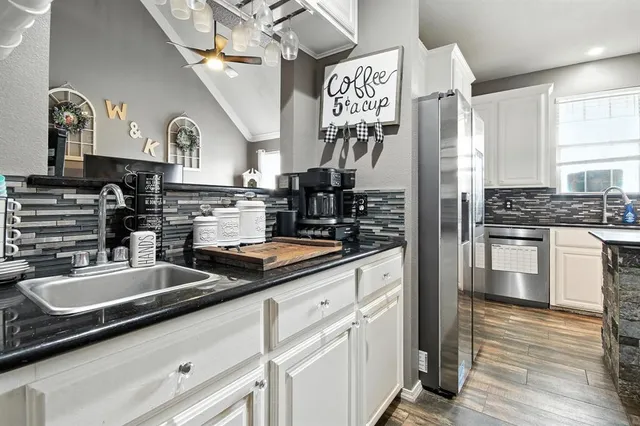 a kitchen with stainless steel appliances granite countertop a sink and cabinets