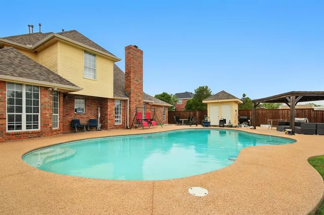 a front view of a house with swimming pool having outdoor seating
