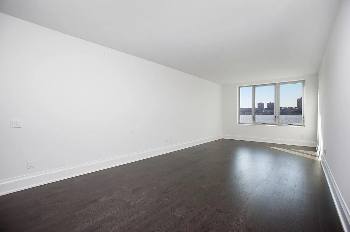 50 Riverside Boulevard, Unit 5B Manhattan, NY 10069 - Photo 3 of 26 an empty room with wooden floor and windows