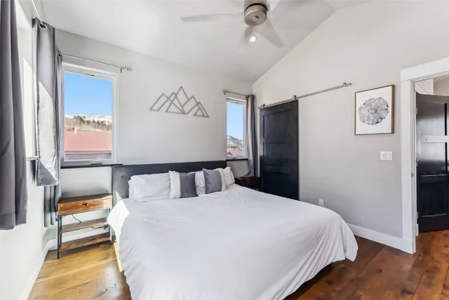 a bedroom with a bed and painting on the wall