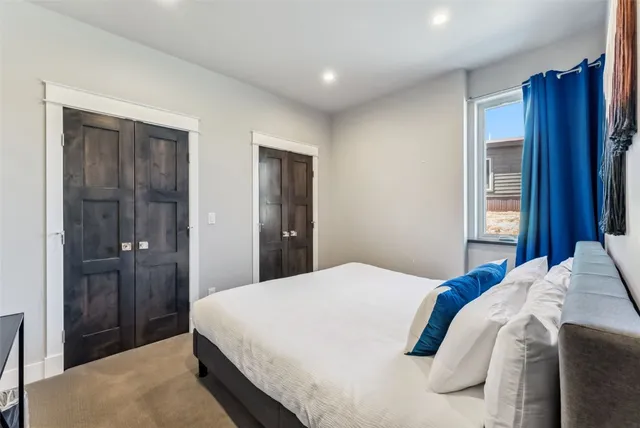 a large bed in a bedroom next to a window