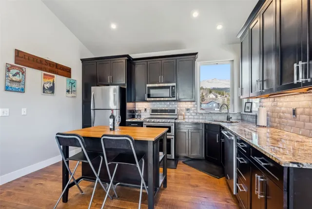 a kitchen with granite countertop a stove top oven microwave and cabinets