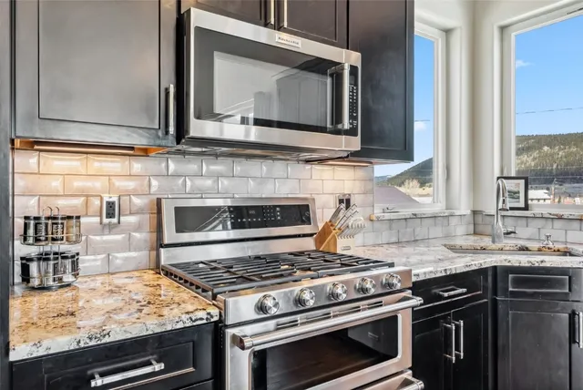 a kitchen with stainless steel appliances granite countertop a sink stove and cabinets