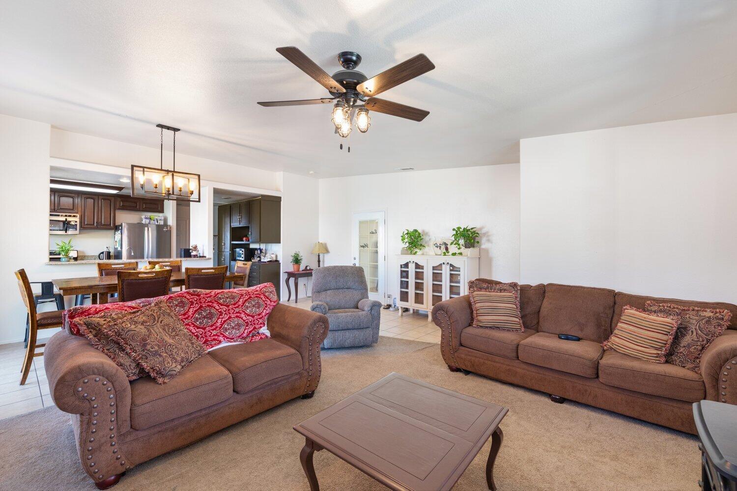 14290 Rafael Street Cabazon, CA 92230 - Photo 13 of 41 a living room with furniture kitchen view and a chandelier