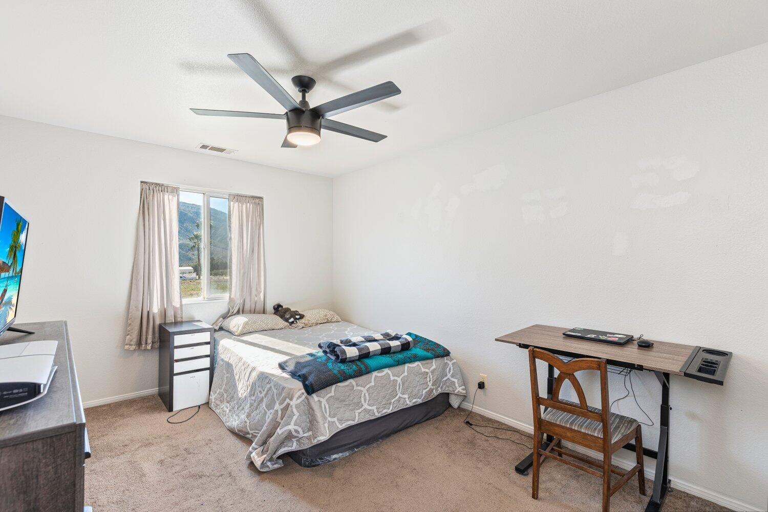 14290 Rafael Street Cabazon, CA 92230 - Photo 17 of 41 a bedroom with a bed and a desk