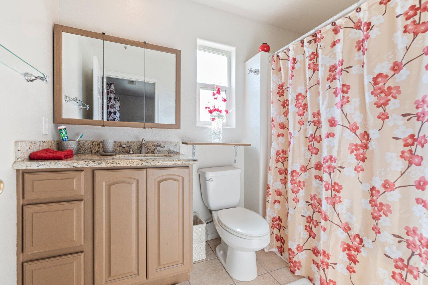 14290 Rafael Street Cabazon, CA 92230 - Photo 22 of 41 a bathroom with a granite countertop sink and a mirror