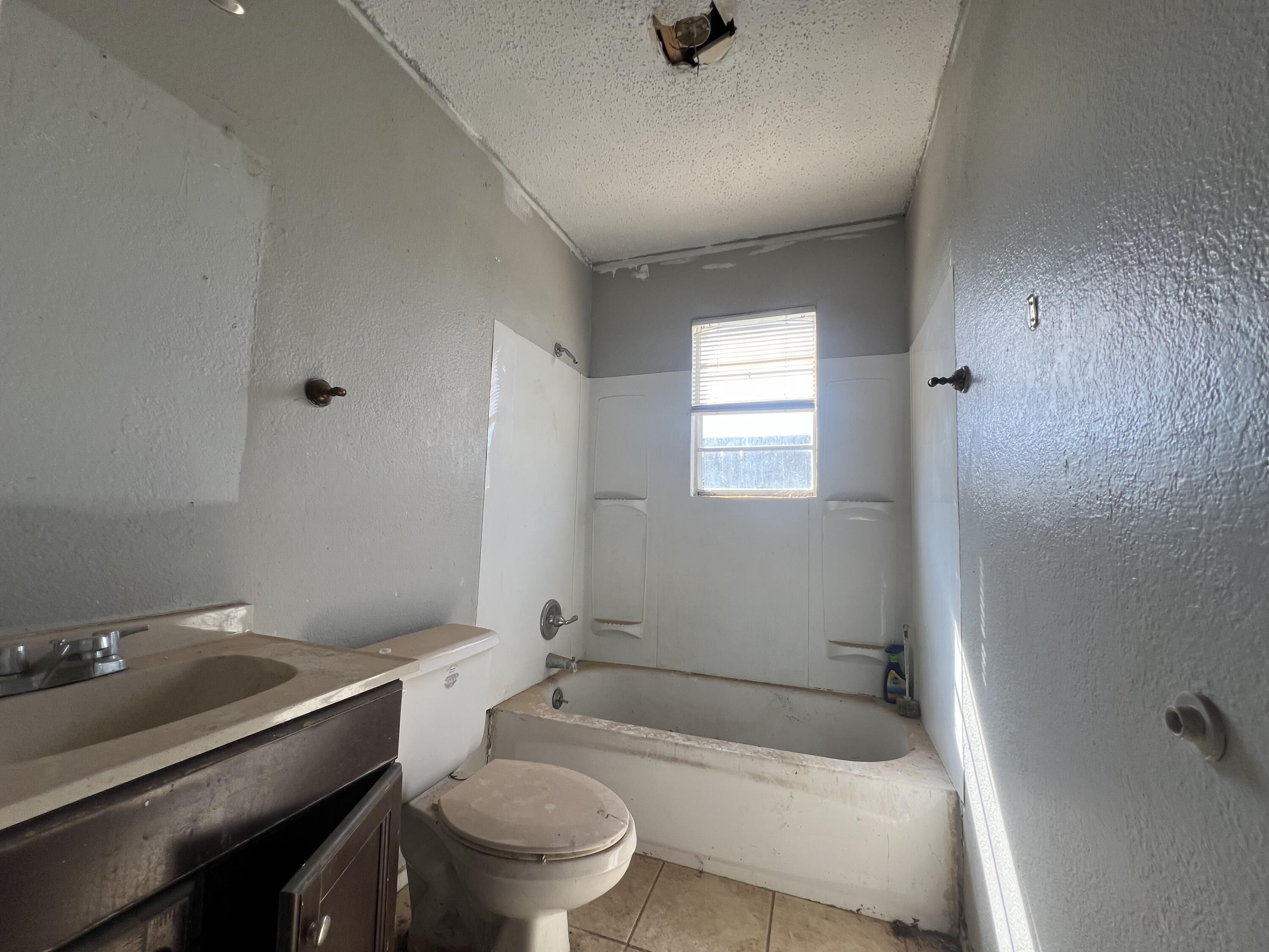 1309 32nd Street Lubbock, TX 79411 - Photo 21 of 28 a bathroom with a sink a toilet and shower
