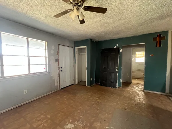 an empty room with closet and a chandelier fan