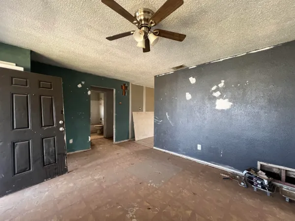 en empty room with windows and ceiling fan
