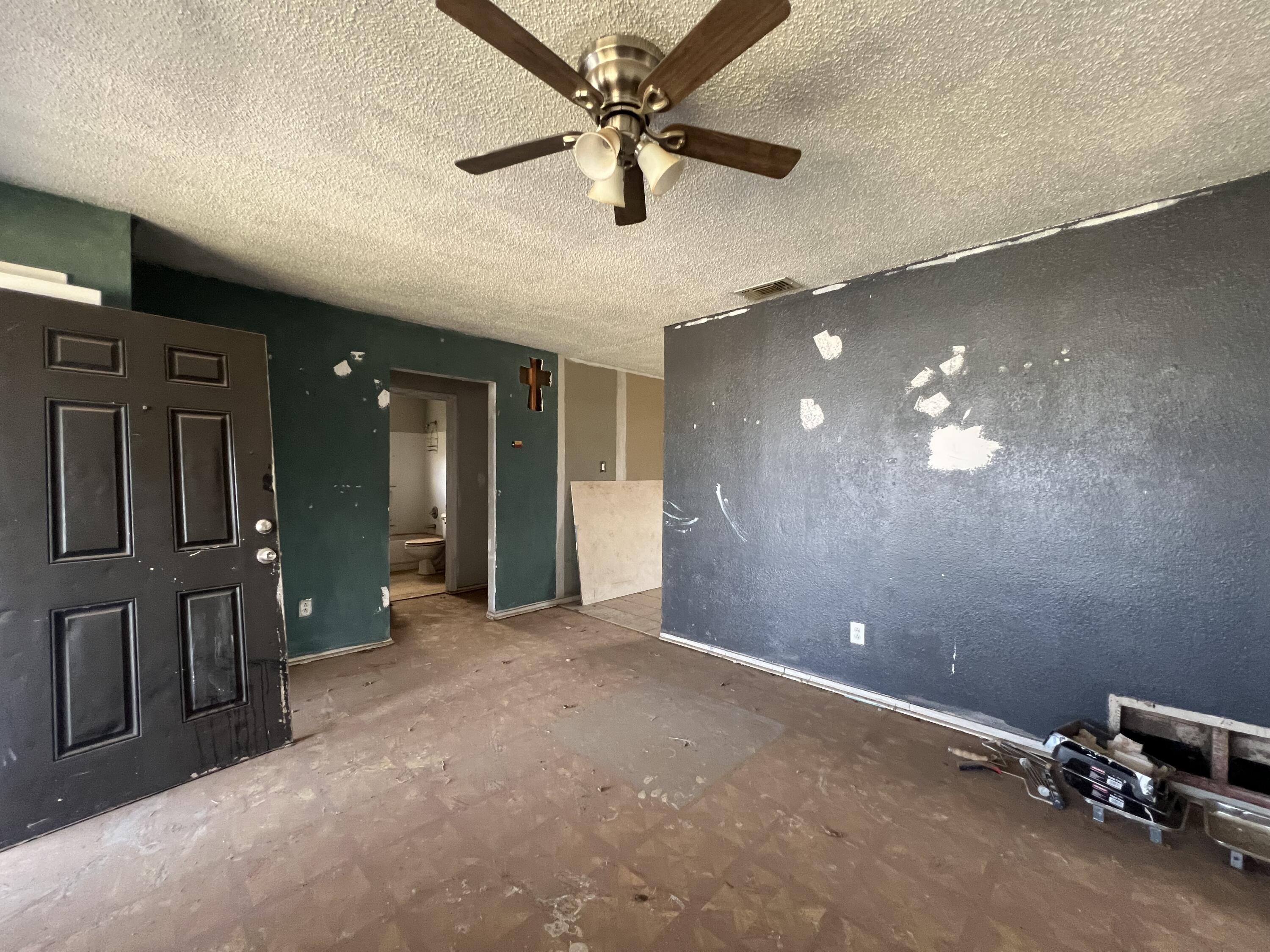 1309 32nd Street Lubbock, TX 79411 - Photo 5 of 28 en empty room with windows and ceiling fan