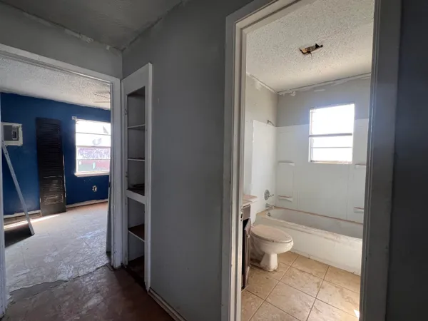 a bathroom with a granite countertop toilet a sink and mirror