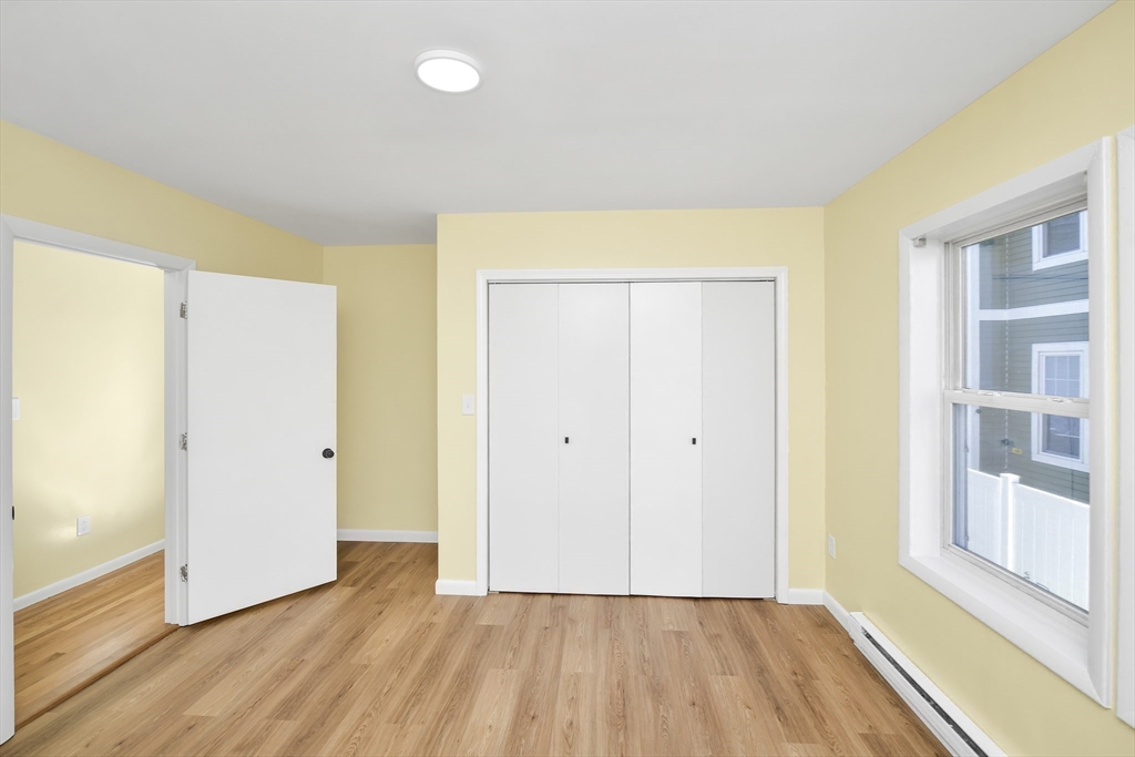 11 Greendale Road, Unit 2 Boston, MA 02126 - Photo 16 of 25 a view of an empty room with wooden floor and a window