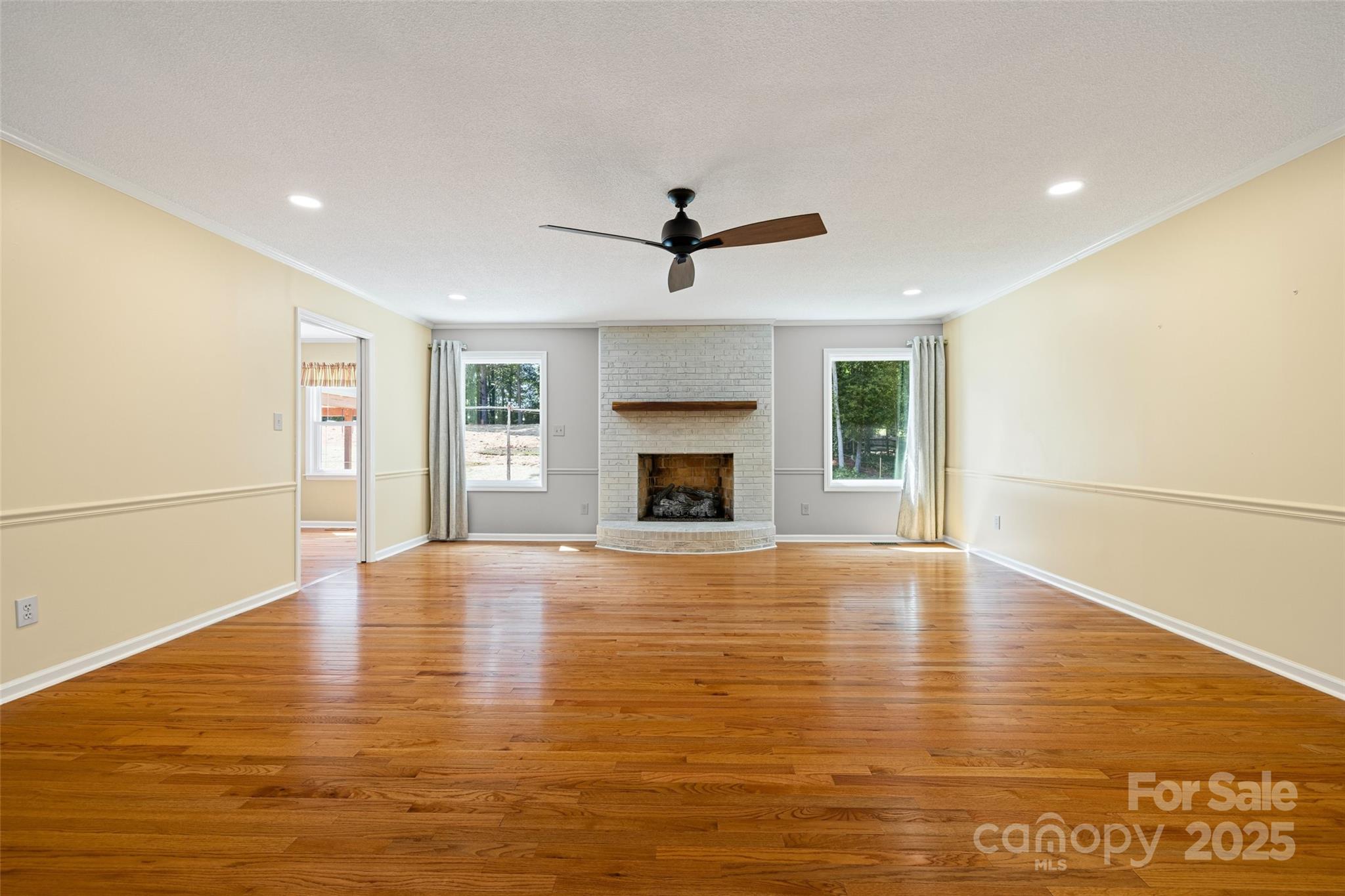 229 Campsite Road Rock Hill, SC 29732 - Photo 8 of 45 an empty room with wooden floor fireplace and windows