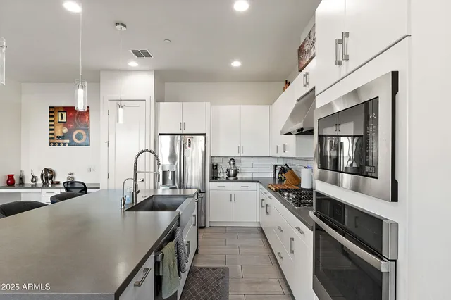 a kitchen with stainless steel appliances a sink stove and refrigerator
