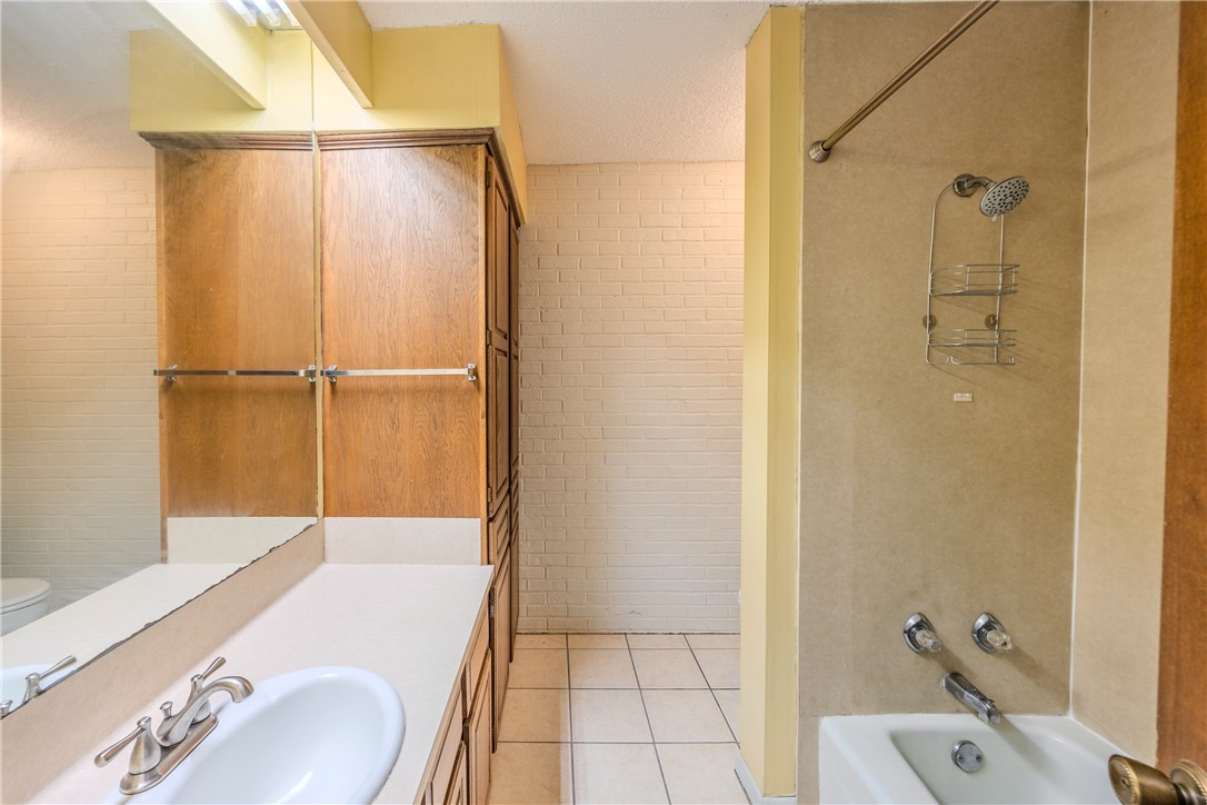 2002 South Lubbock Street Brenham, TX 77833 - Photo 23 of 26 Bathroom with shower / tub combination, vanity, and light tile patterned floors