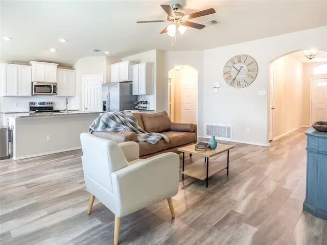 a kitchen with stainless steel appliances granite countertop a sink dishwasher stove and refrigerator with wooden floor