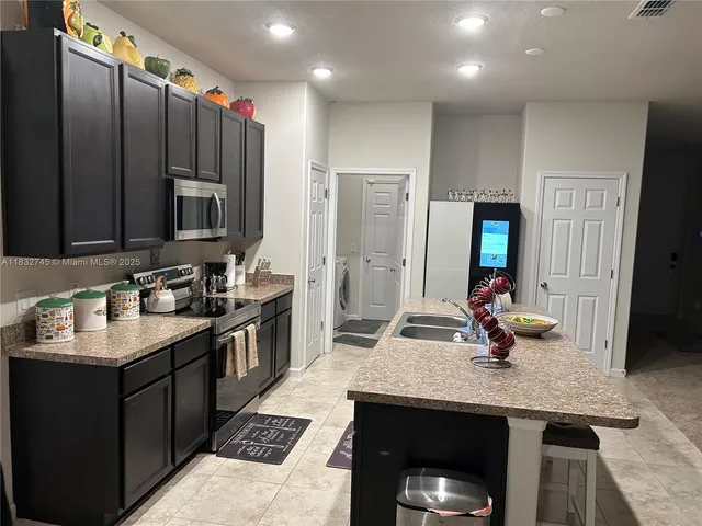 a kitchen with stainless steel appliances granite countertop a sink stove and cabinets