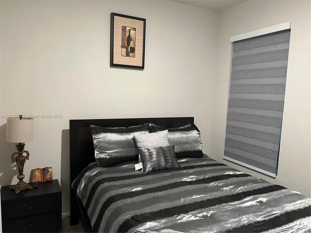 a bed sitting in a bedroom next to a window