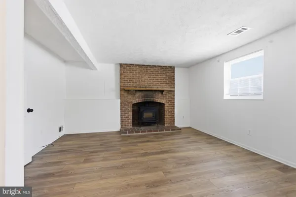 a view of an empty room with a fireplace and a window