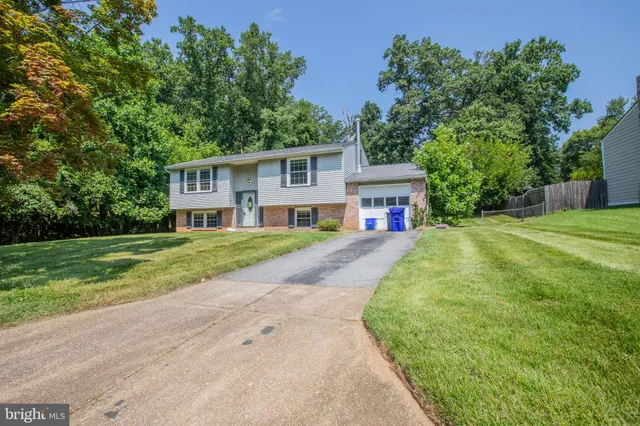 a view of house with outdoor space and trees around