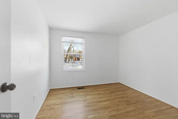 an empty room with a wooden floor and a window