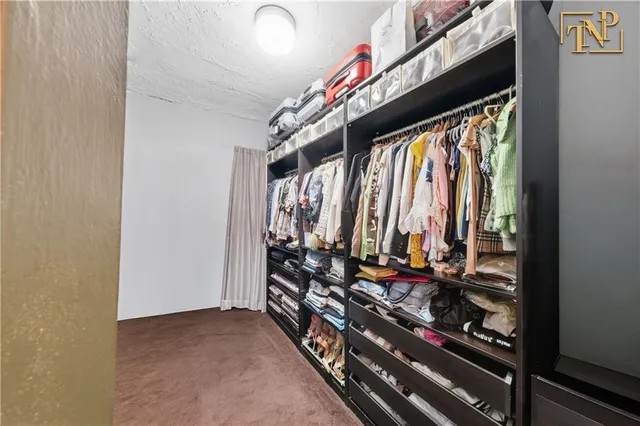 a view of walk in closet with clothes and shoes