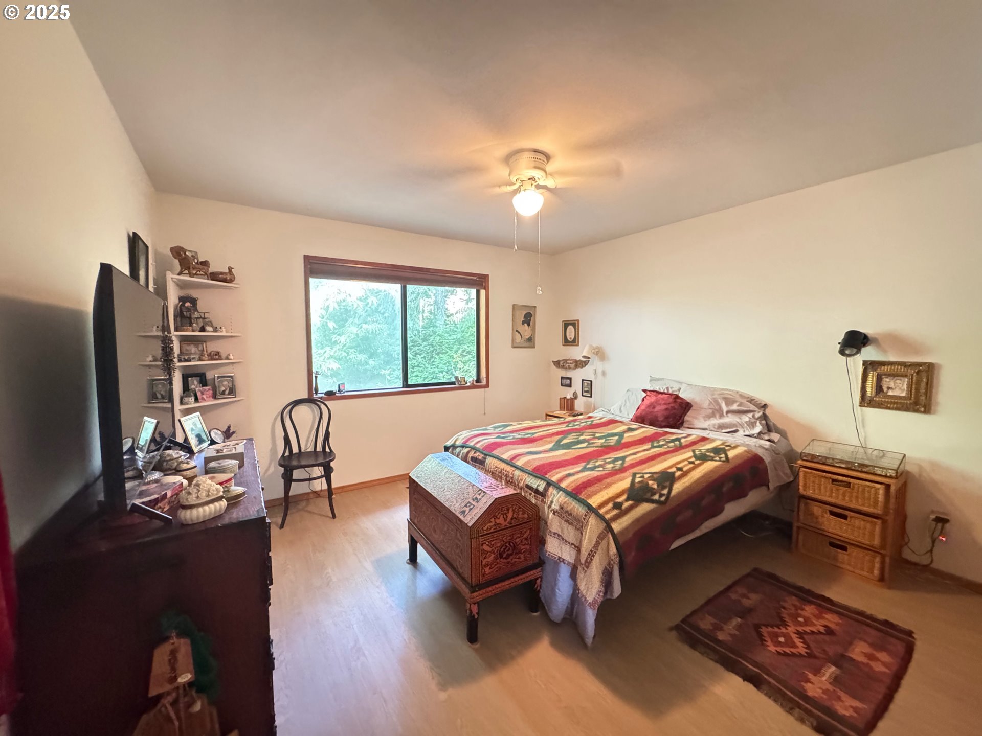 88468 Trout Pond Lane Southwest Bandon, OR 97411 - Photo 13 of 44 a bedroom with a bed and a chandelier
