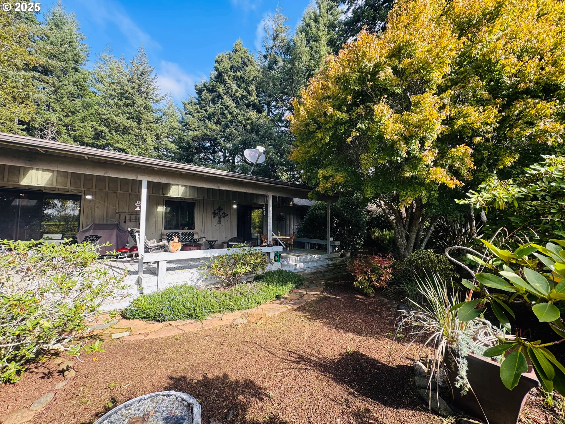 88468 Trout Pond Lane Southwest Bandon, OR 97411 - Photo 33 of 44 a view of a backyard with sitting area and garden