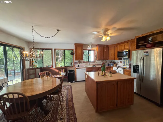 a kitchen with stainless steel appliances granite countertop a sink a stove and a refrigerator
