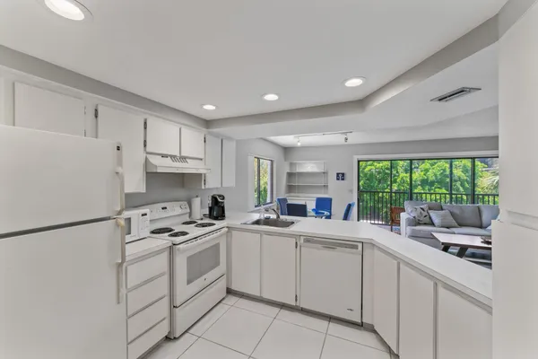 a kitchen with white cabinets and white appliances